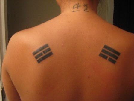 Two asian symbols tattoo on back