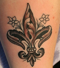 Le tatouage de fleur de lys avec des fleurs