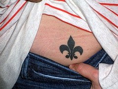 Tatuaje flor de lis en bajo espalda