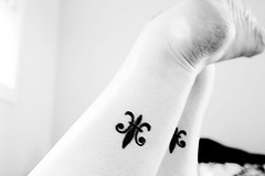 Fleur de lis tattoo on both legs