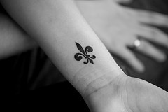 Un petit tatouage de fleur de lys sur le poignet