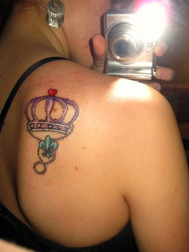 Tatuaje flor de lis con corona en hombro
