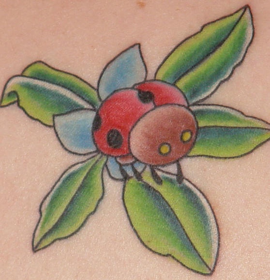 Tatuaje de mariquita en una flor azul con hojas