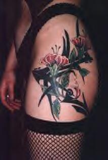 Tatuaje en cadera de flores y tracería