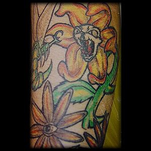 Le tatouage d&quotune fleur en coller  qui attaque une abeille sur le bras
