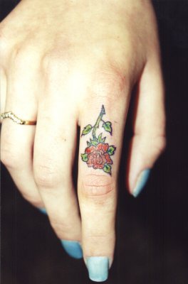 Small red rose tattoo on finger