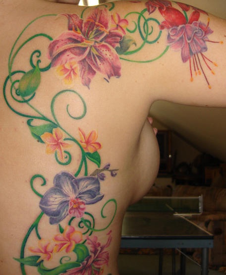 Tatuaje en color la vid con las flores brillantes en la espalda y el hombro