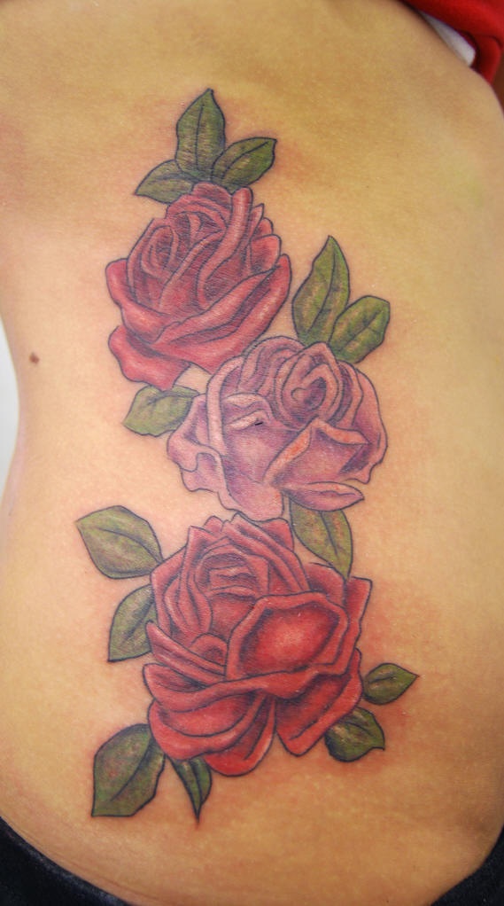 Le tatouage sur le flanc avec des belles roses