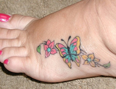 Coloured butterfly on flowers foot tattoo