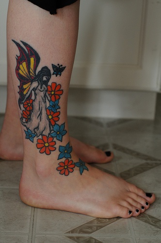 Tatuaje en el pie, chica con alas entre flores