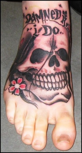 Tatuaje en el pie, cráneo con dientes y letrero maldito si lo hago yo