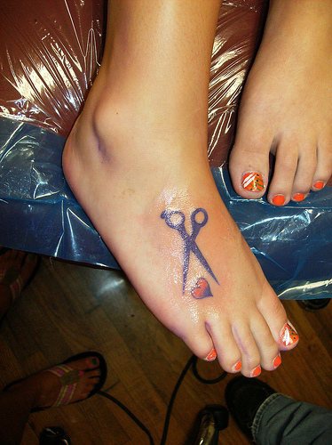 Le tatouage sur le pied de cœur et des ciseaux