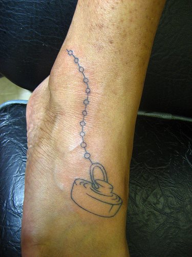 Tatuaje en el pie, enchufe de baño con cadena
