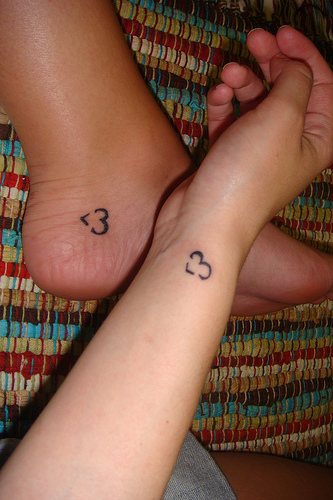 Due piccoli tatuaggi sul braccio e sul piede piccolo cuore