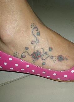Sottile tatuaggio sul piede ramoscelli e fiori