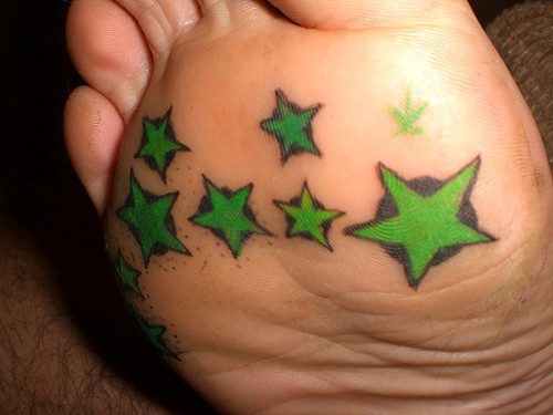 Tatuaje en el pie, muchas estrellas de color verde brillante