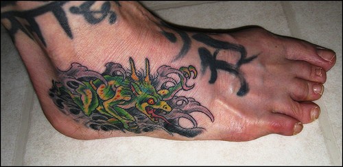 Vermi e la scrittura tatuati sul piede