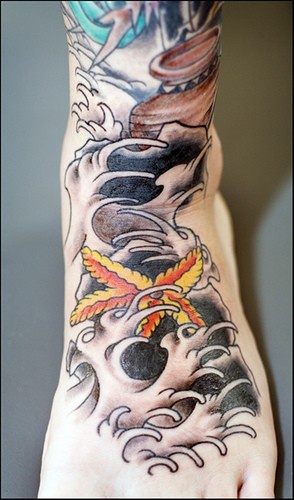 Étoile de mer dans les vagues orageux avec le tatouage de cruche sur le pied