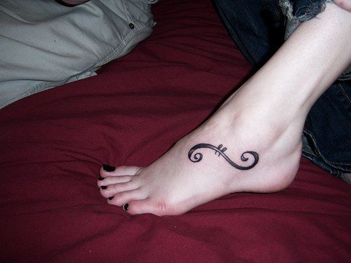 Accurato ricciolo tatuato sul piede