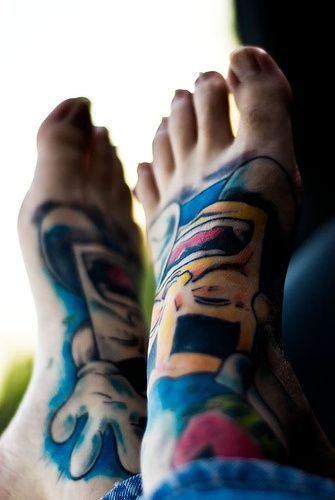 Scatole giallo-bianche tatuate sui piedi