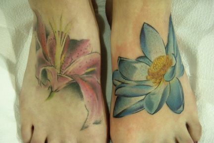 Schönes Tattoo von  blauen und rosa Lilien auf Füßen