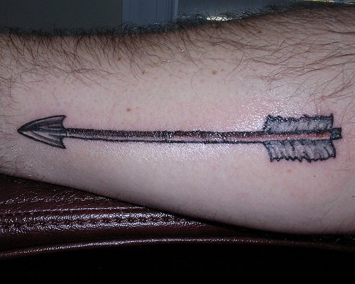 Tattoo von langem scharfem schönem geradem Pfeil am Unterarm