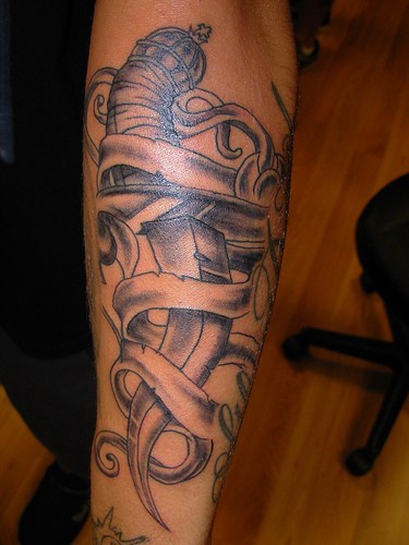 Tattoo von schönem gebogenem scharfem Dolch am Unterarm