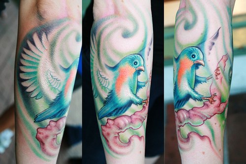 Pittoresco tatuaggio uccello colorato sul ramo