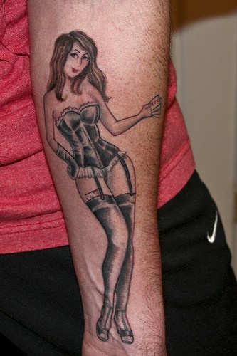 Ragazza in biancheria intima con i capelli lungi tatuata sul braccio