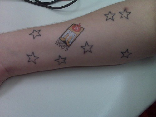 Coloured sticker & and seven stars forearm tattoo