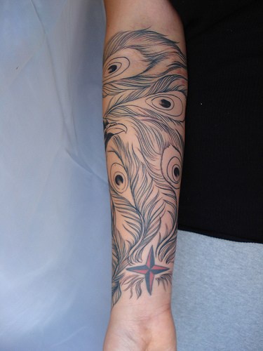 Le piume di pavone tatuati sul braccio