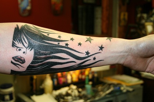 Tatuaje en el antebrazo, mujer con el cabello negro, estrellas