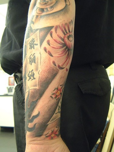 Beautiful flower and sheet with hieroglyphs forearm tattoo