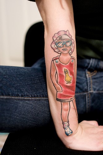 Fashioned girl in glasses and cap forearm tattoo