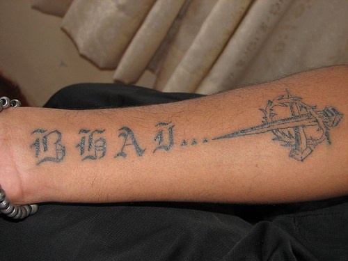 Long styled inscription with sharp object forearm tattoo