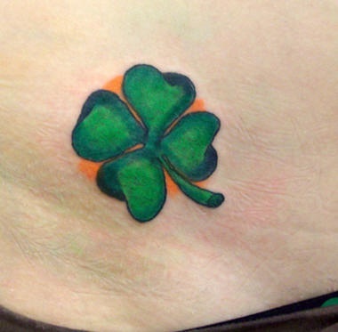 Four leaf clover on orange background tattoo