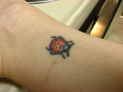 Small red ladybug tattoo