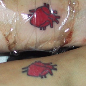Identical realistic heart tattoos on lovers