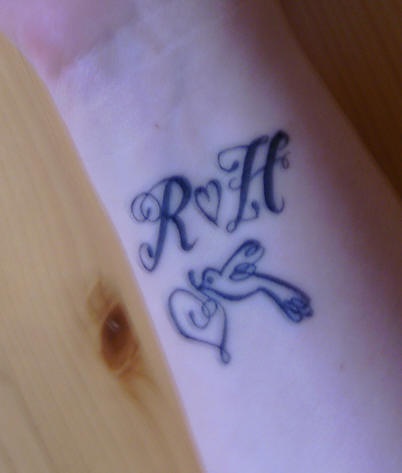 Tatuaje de iniciales, un corazón y un pajaro