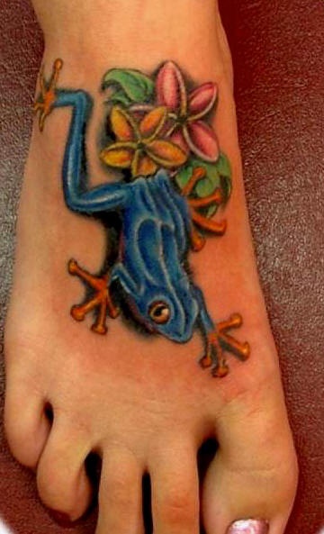 Le tatouage de grenouille bleu avec une branche de fleurs sur le pied