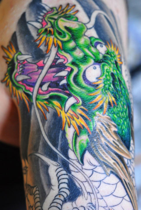 Le tatouage coloré de dragon vert asiatique très étonné