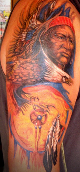 el tatuaje de un indio junto con una aguila hecho en color en el brazo