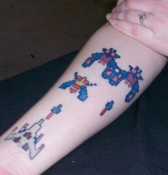 Galaga game coloured tattoo on arm
