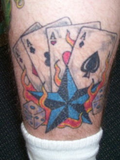 Quattro assi con stella blu tatuaggio sulla gamba