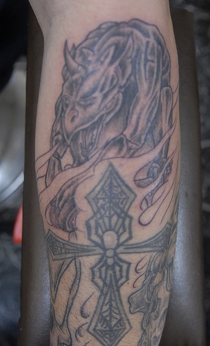 tatuaje de bestia gárgola y cruz en llamas