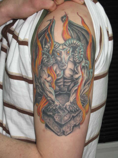 tatuaje en el brazo de gárgola en llamas con cabeza de cabra