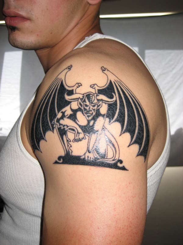 tatuaje minimalista en tinta negra en el hombro de gárgola