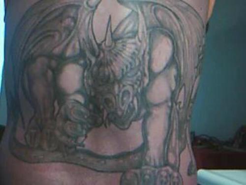 Gargoyle with creepy face tattoo