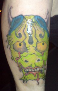 Green gargoyle deamon head tattoo