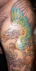 Colourful winged griffon tattoo on arm
